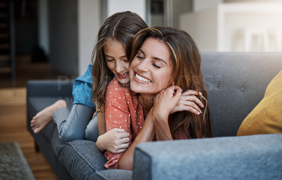 Buy stock photo Full length shot of an attractive young woman and her daughter hugging while spending time together at home