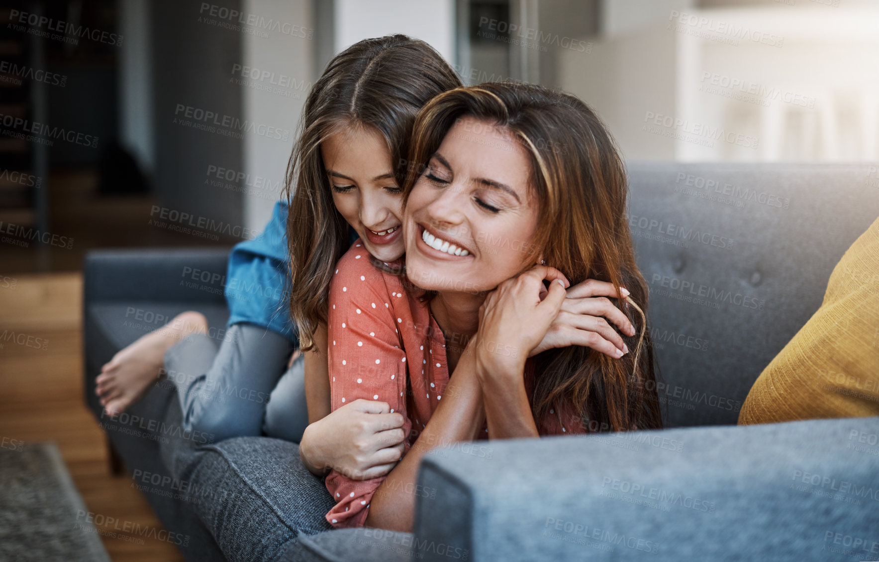 Buy stock photo Full length shot of an attractive young woman and her daughter hugging while spending time together at home