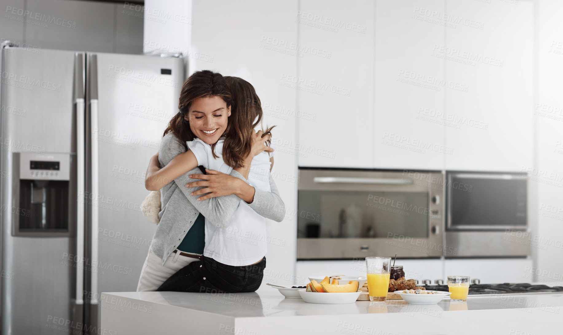 Buy stock photo Cropped shot of an attractive young woman and her daughter hugging while spending time together at home