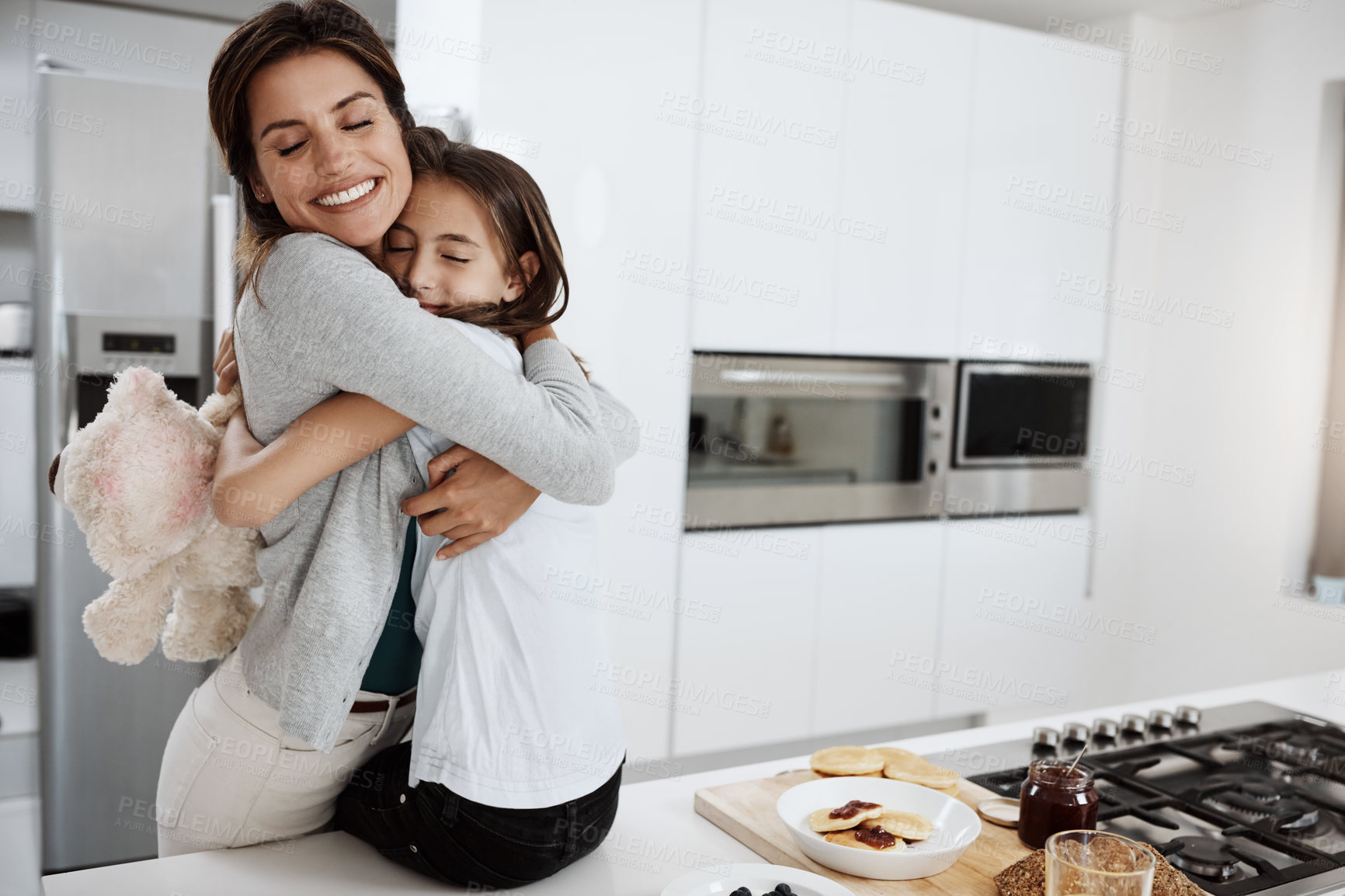 Buy stock photo Cropped shot of an attractive young woman and her daughter hugging while spending time together at home