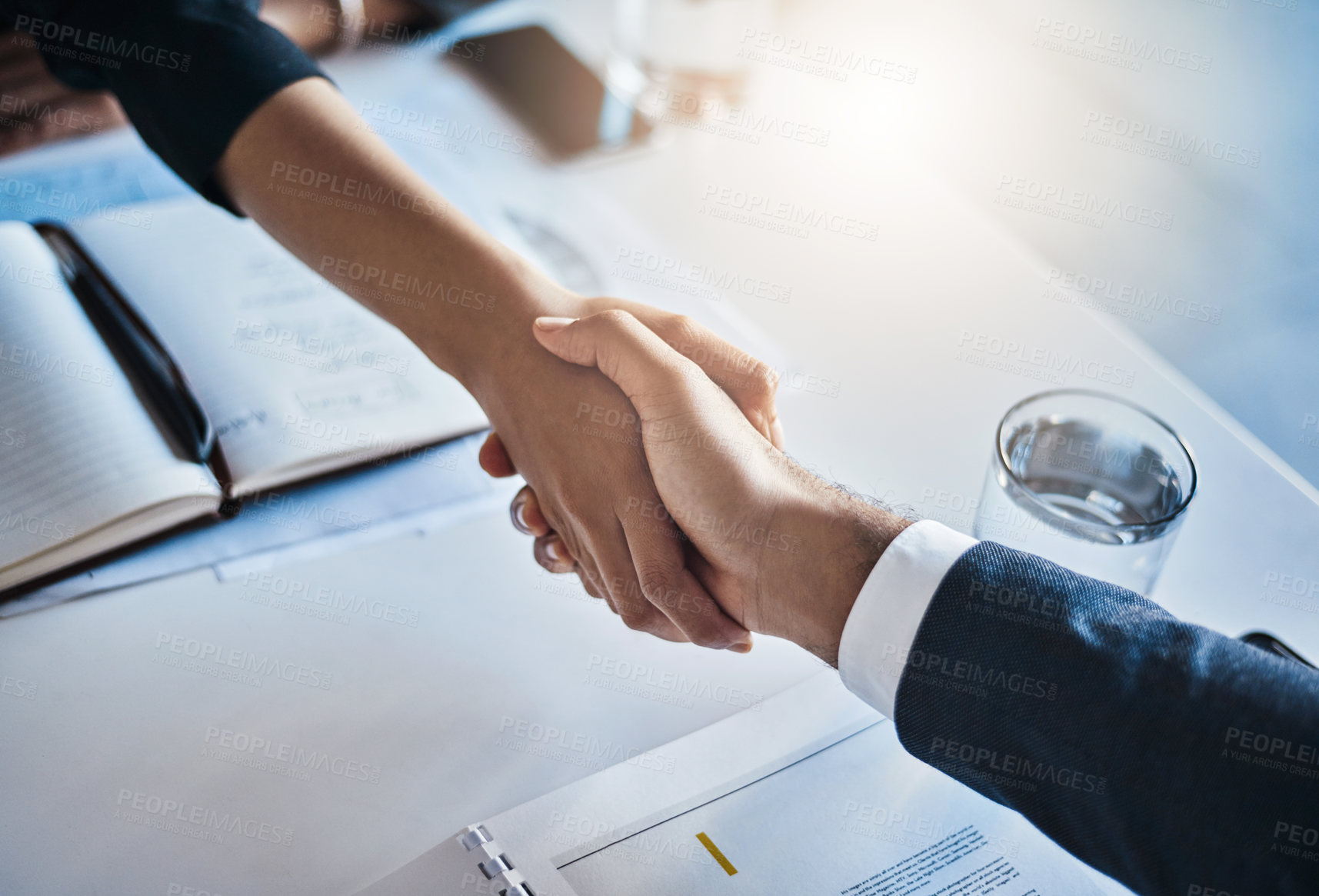 Buy stock photo Closeup shot of two unrecognizable businesspeople shaking hands in an office