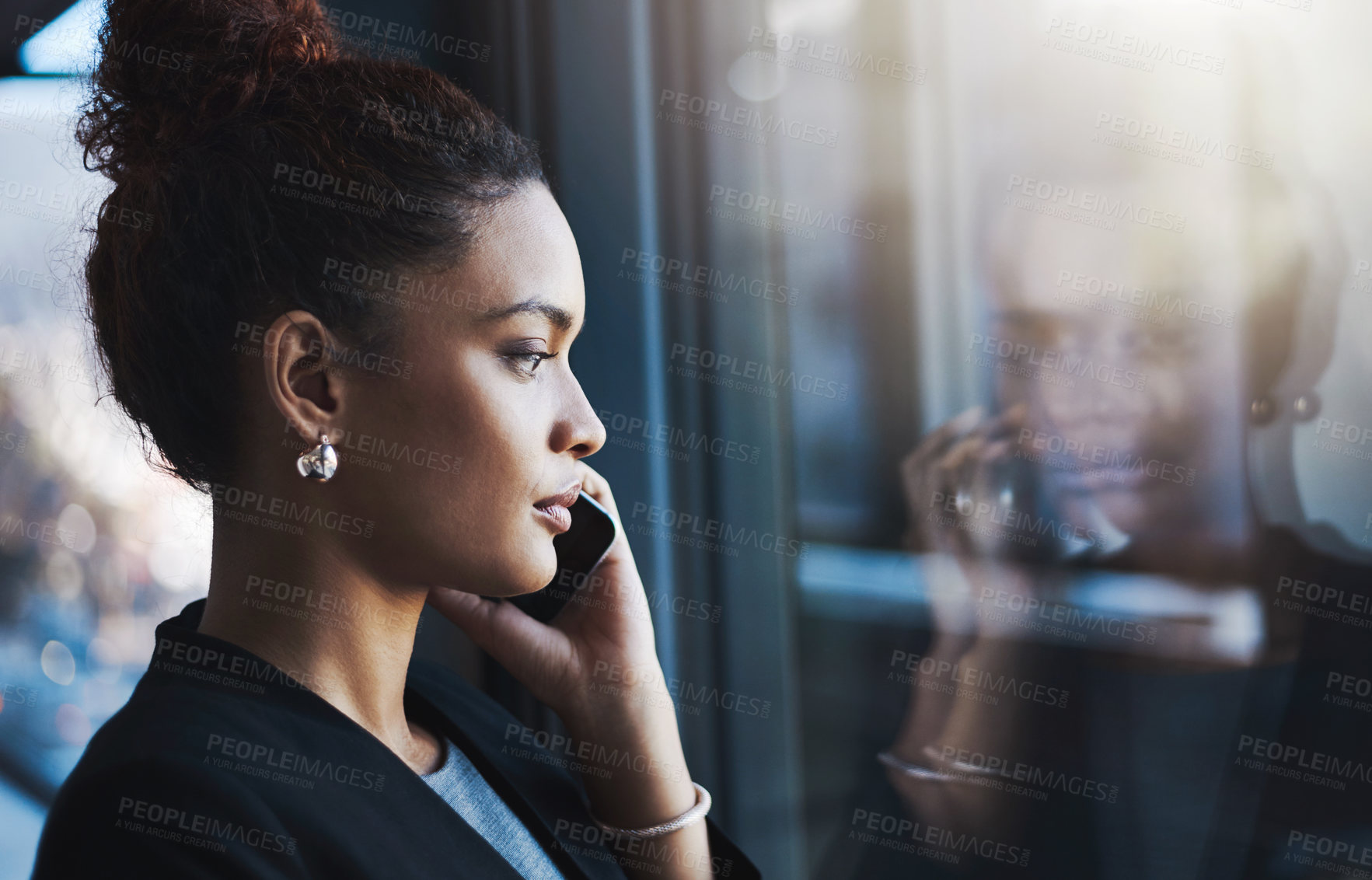 Buy stock photo Shot of a young businesswoman talking on a cellphone in an office