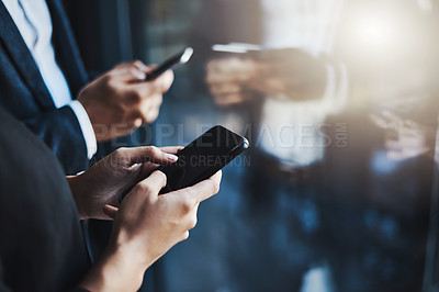 Buy stock photo Closeup shot of two unrecognizable businesspeople using their cellphones in an office