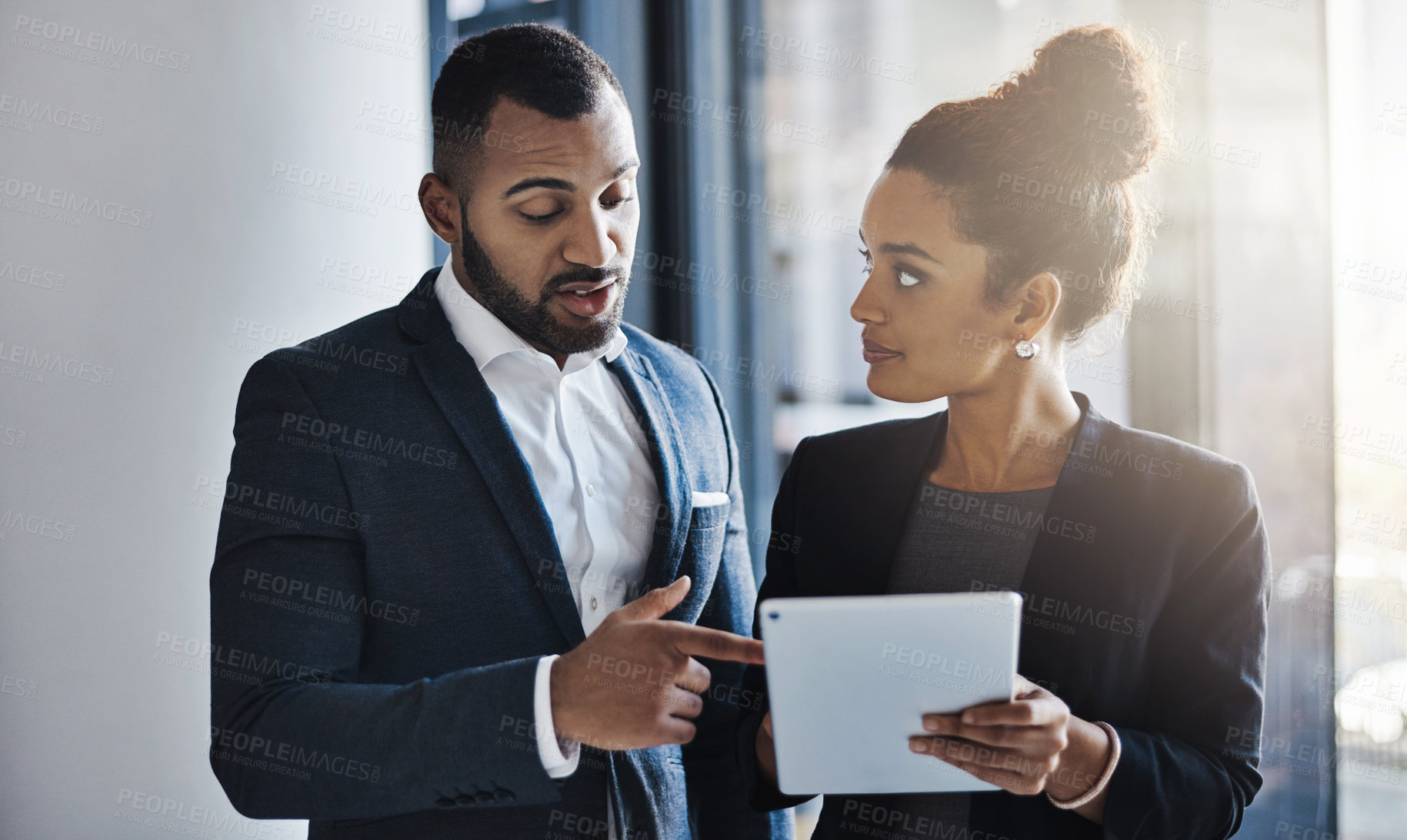 Buy stock photo Shot of two businesspeople working together on a digital tablet in an office