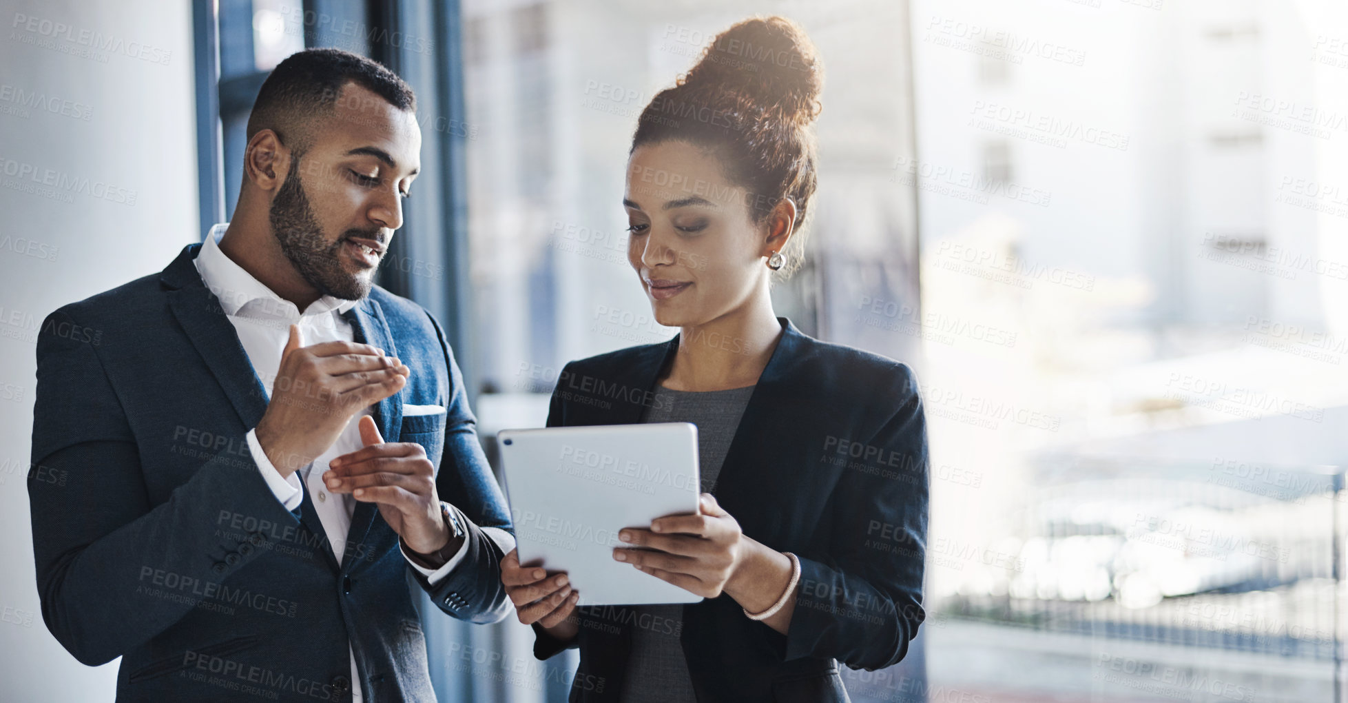 Buy stock photo Shot of two businesspeople working together on a digital tablet in an office