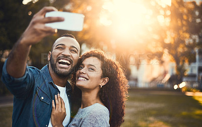 Buy stock photo Shot of a young couple taking selfies together outdoors
