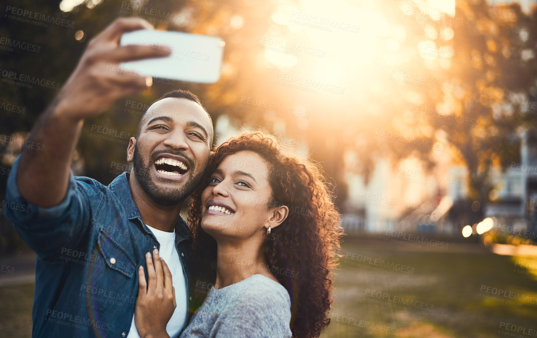 Buy stock photo Shot of a young couple taking selfies together outdoors