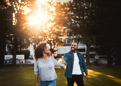 Buy stock photo Happy, holding hands and couple in park walking for bonding, relationship and love outdoors. Nature, dating and man and woman for romance, affection and commitment on weekend to relax together