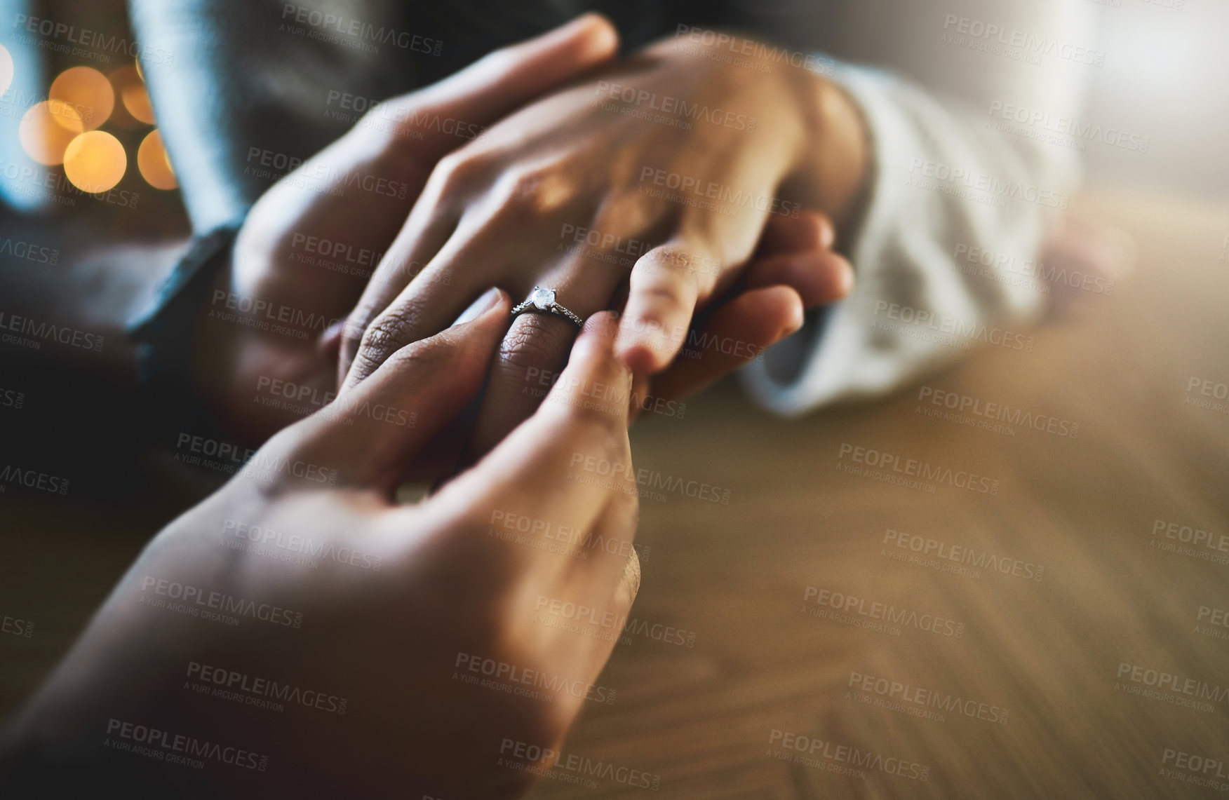 Buy stock photo Cropped shot of a man putting an engagement ring onto his girlfriend's finger