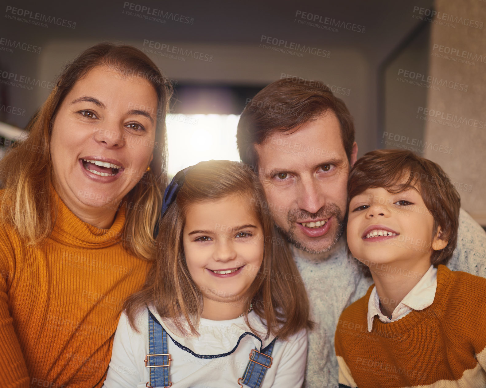 Buy stock photo Cropped portrait of an affectionate young family of four sitting on the sofa at home