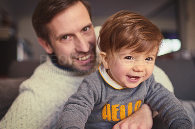 Buy stock photo Cropped portrait of a handsome man spending some quality time with his adorable young son at home