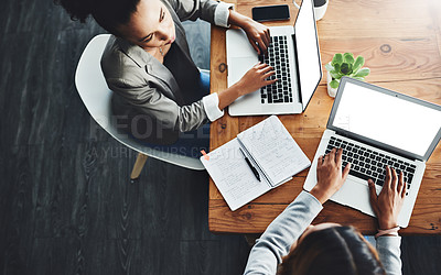 Buy stock photo Above view of professional employees talking and working together on a strategy project on their laptop in a modern office. Corporate colleagues sitting in a formal business meeting, discussing plans