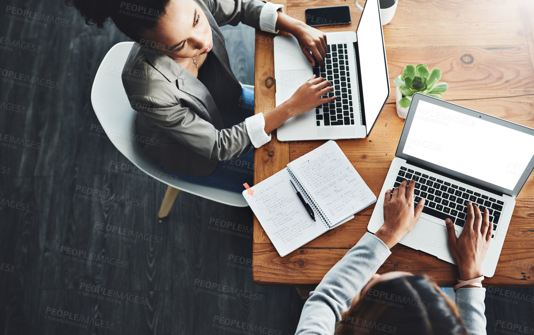 Buy stock photo Above view of professional employees talking and working together on a strategy project on their laptop in a modern office. Corporate colleagues sitting in a formal business meeting, discussing plans