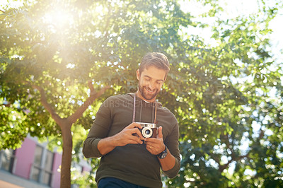 Buy stock photo Cropped shot of a handsome young man taking photographs during his morning commute
