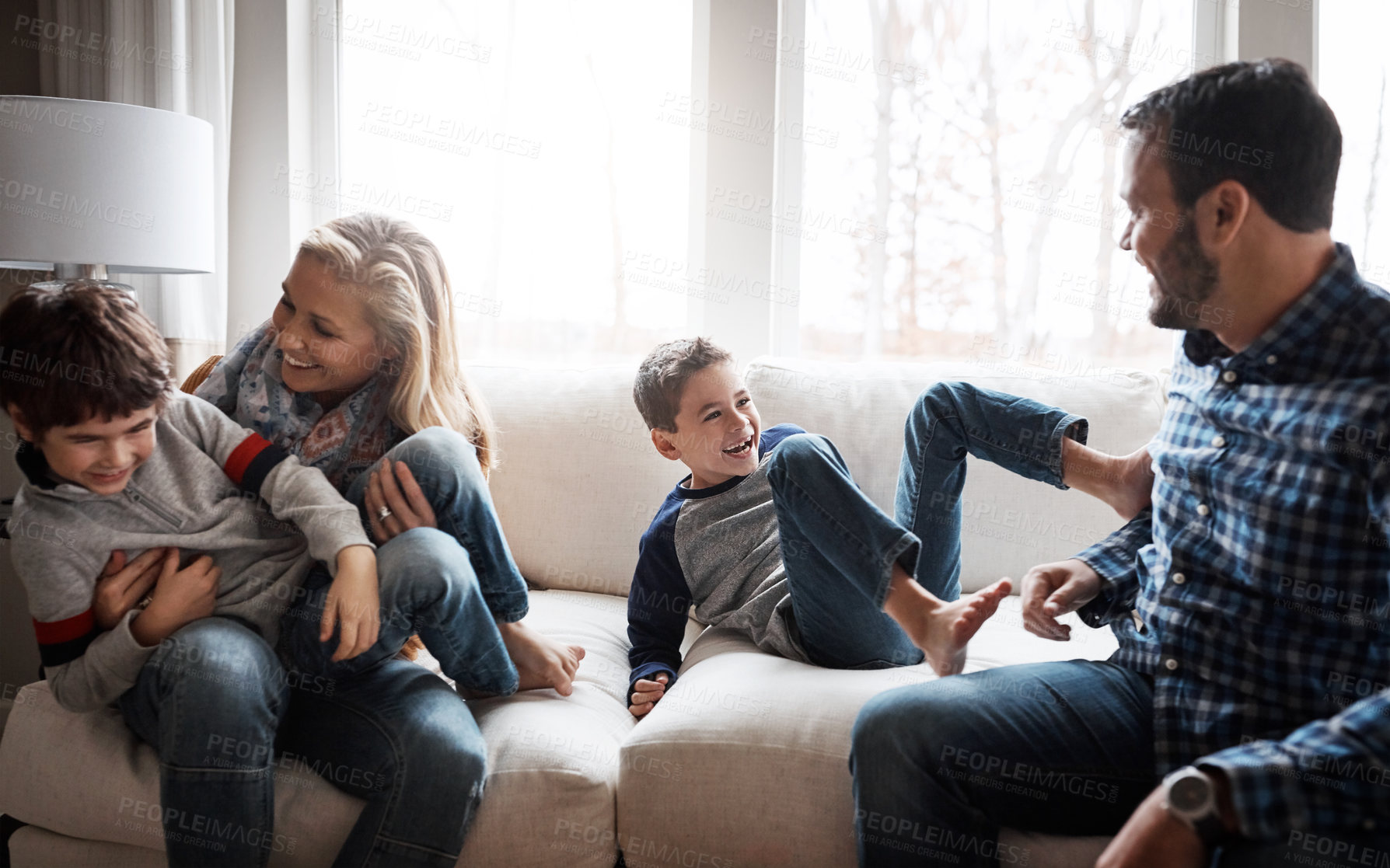 Buy stock photo Love, bonding and family on the sofa for fun, playing and playful energy in their house. Relax, happy and parents with crazy children to play wrestle on the couch during quality time in a home