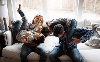 Buy stock photo Playful, funny and family on the sofa with energy for fun, playing and bonding in their house. Relax, happy and parents with crazy children to play wrestle on the couch during quality time in a home