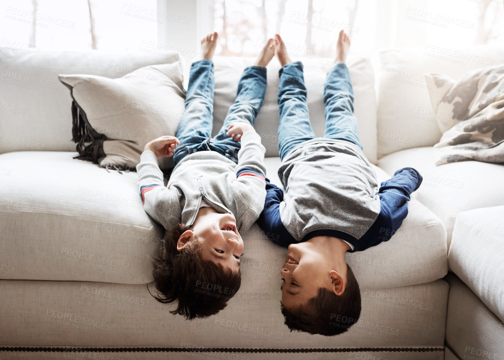 Buy stock photo Children upside down, playing and happy at family home for fun with sibling, brothers on sofa and relax in living room. Happy people, love and quality time together, playful kid boys with laughing