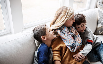 Buy stock photo Shot of two adorable little boys bonding with their mother on the sofa at home