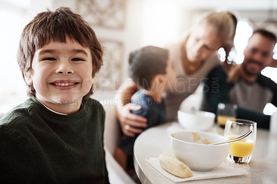 Buy stock photo Portrait of a happy little boy enjoying breakfast together with his family at home