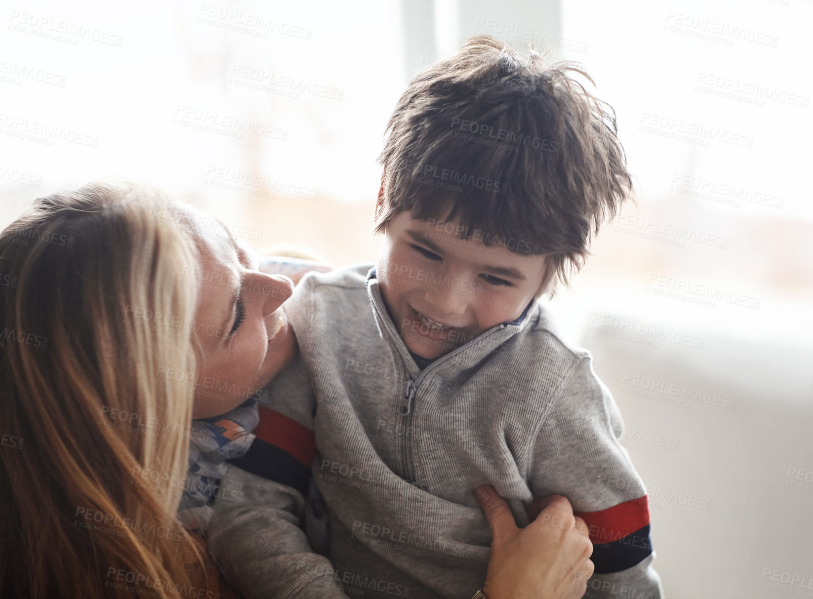 Buy stock photo Shot of an adorable little boy bonding with his mother at home