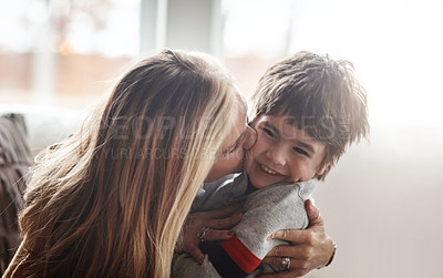 Buy stock photo Family, children and love with a mother kissing her son in the living room of their home while bonding together. Kids, kiss and smile with a woman hugging her boy child on the cheek in a house