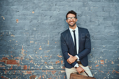 Buy stock photo Cropped portrait of a handsome young businessman standing against a grey facebrick wall