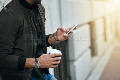 Buy stock photo Cropped shot of an unrecognizable man sending a text while traveling through the city