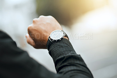 Buy stock photo Cropped shot of an unrecognizable man checking the time while traveling through the city
