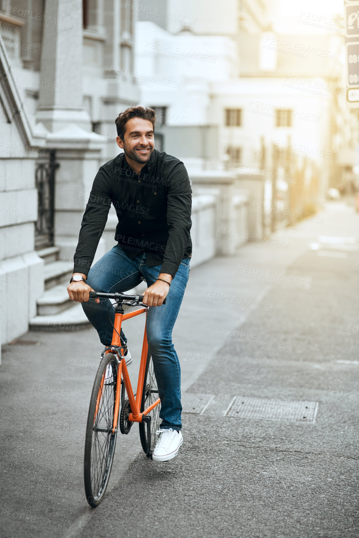 Buy stock photo Full length shot of a handsome young man traveling through the city by bike
