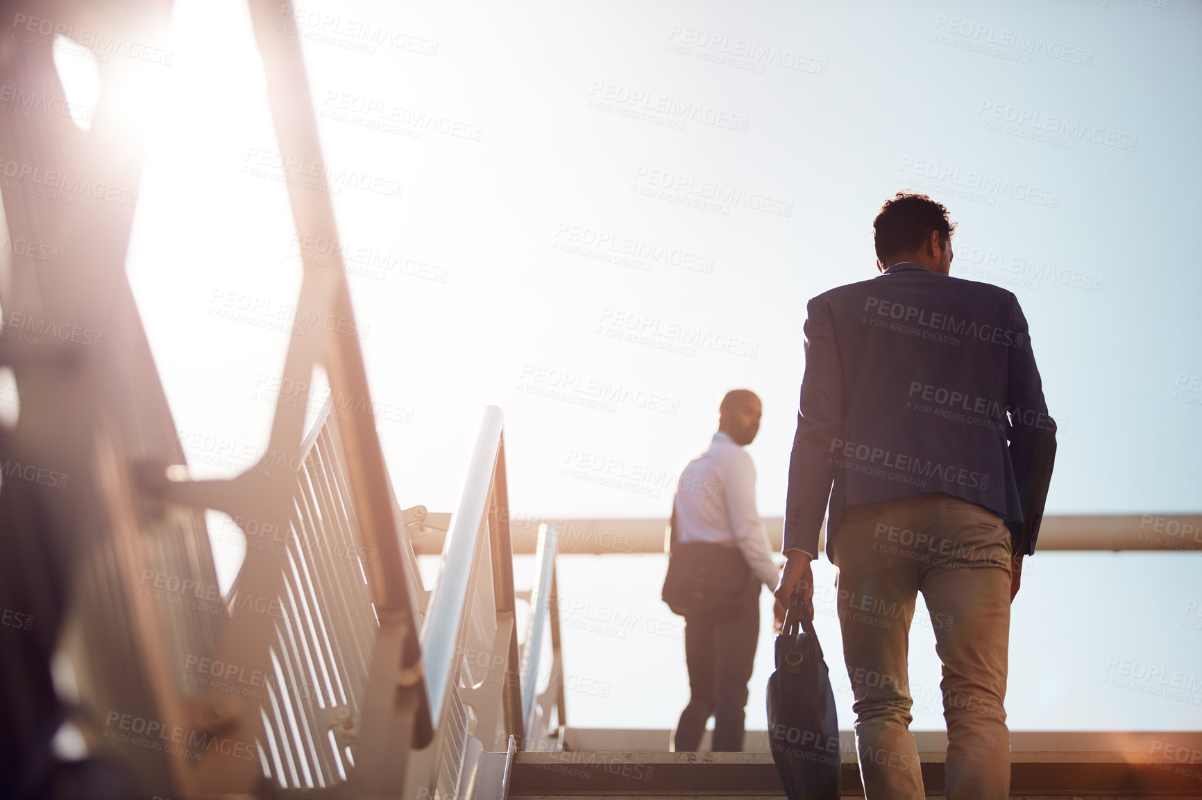 Buy stock photo Business, men and travel on stairs outdoor for commute to work with communication, bag and low angle. People, back and walking together on steps in city for conversation, networking and lens flare