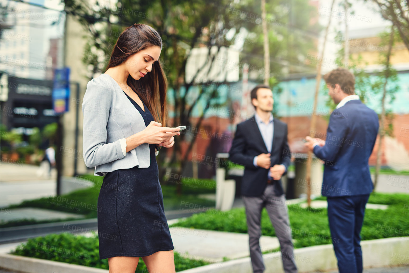 Buy stock photo Cropped shot of a beautiful young businesswoman using a cellphone outside