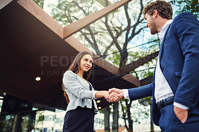 Buy stock photo Cropped shot of a businesswoman and businessman shaking hands outside