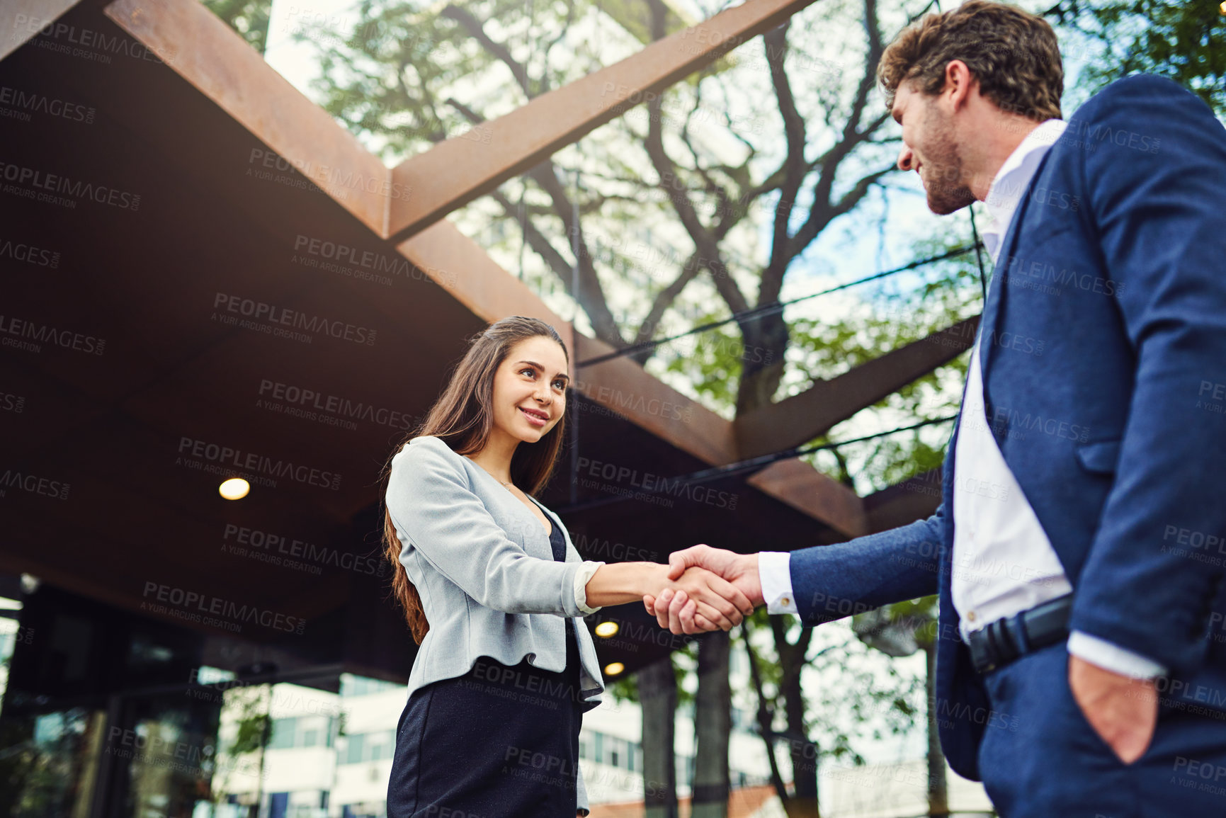 Buy stock photo Cropped shot of a businesswoman and businessman shaking hands outside