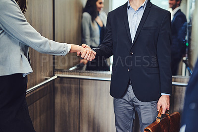 Buy stock photo Cropped shot of unrecognizable businesspeople meeting and greeting in an elevator