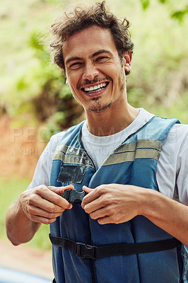 Buy stock photo Cropped shot of a man putting on a life jacket for safety purposes