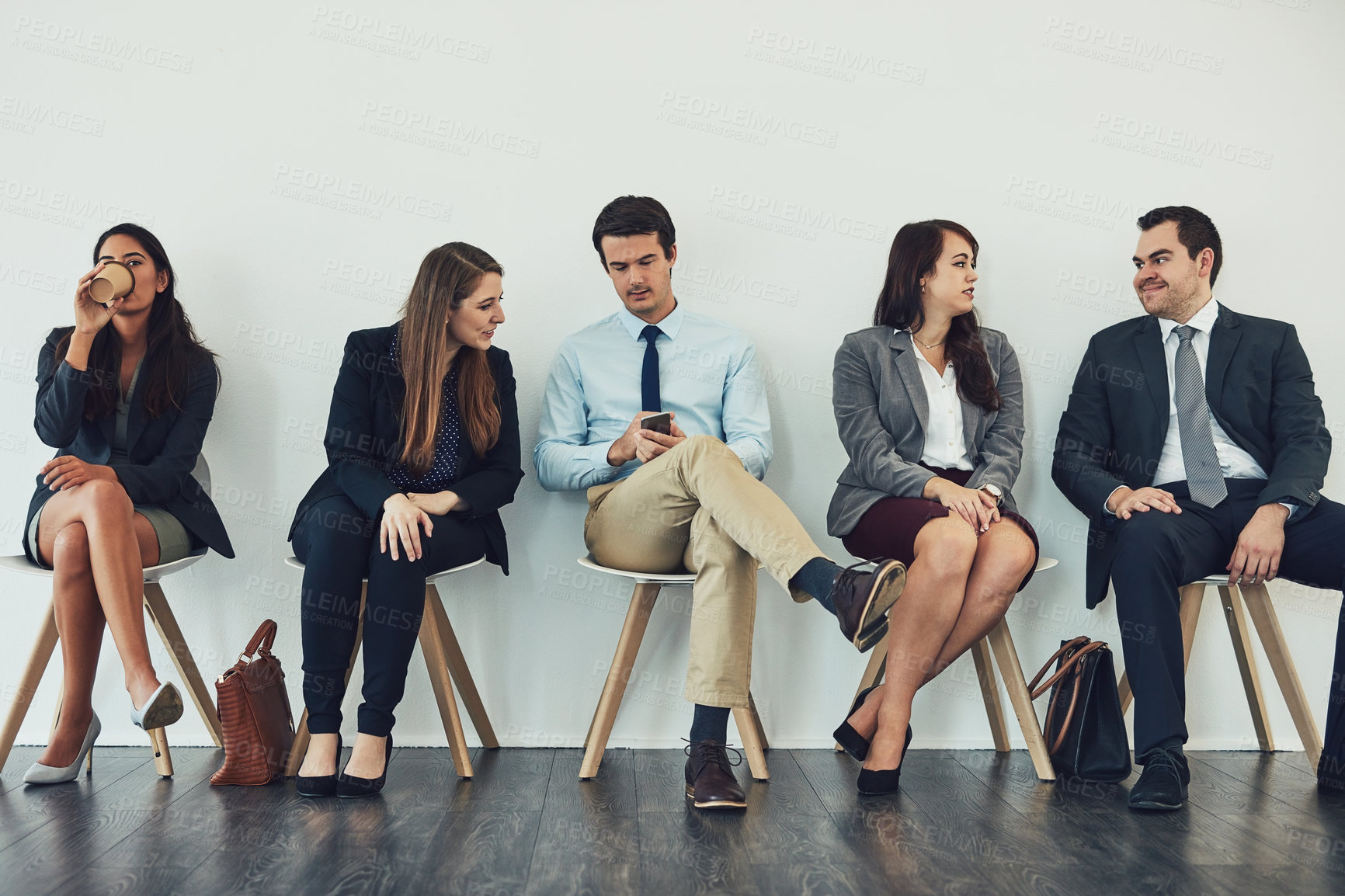 Buy stock photo Studio shot of a group of businesspeople using wireless technology while waiting in line