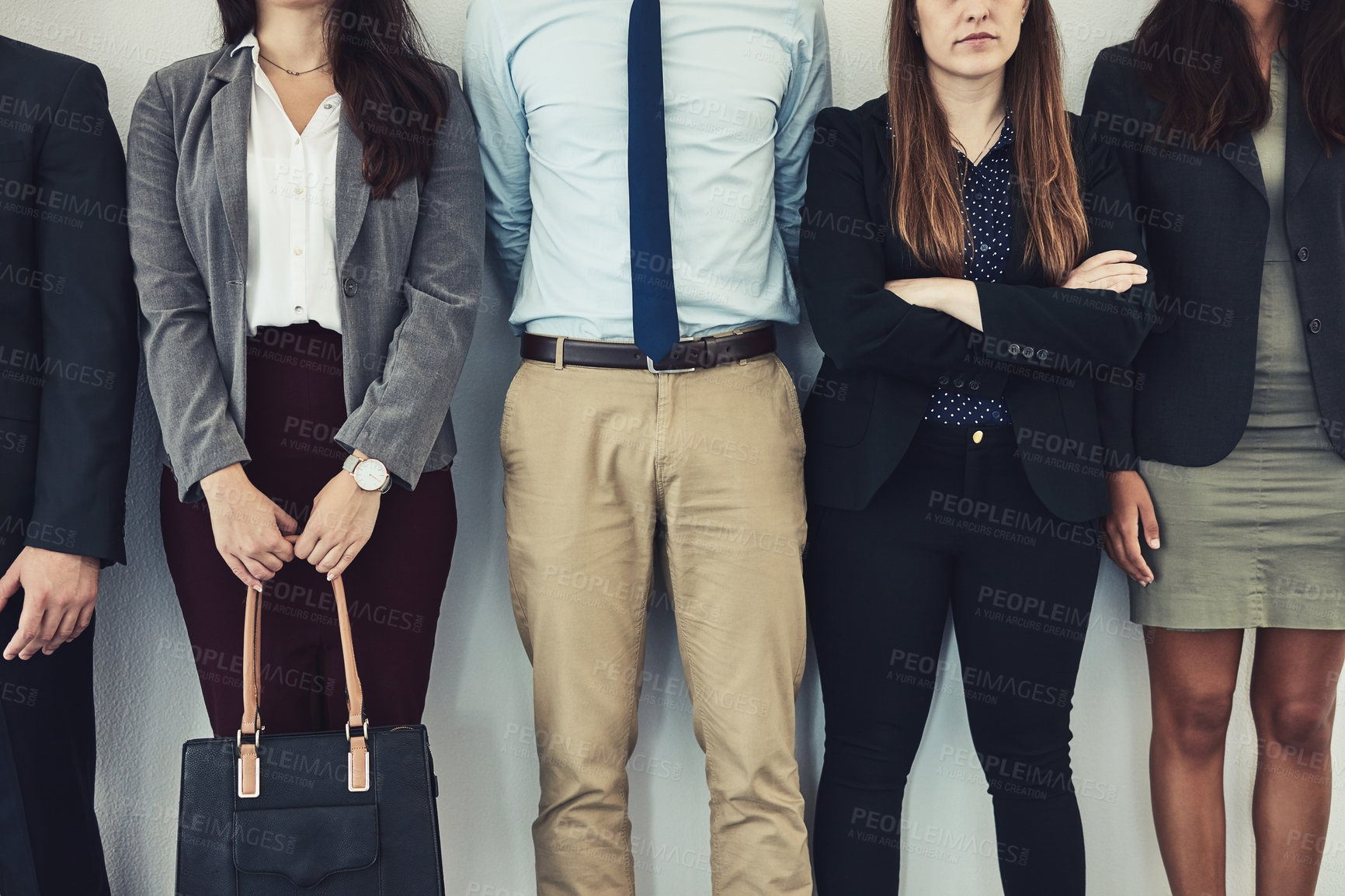 Buy stock photo Cropped studio shot of a group of young businesspeople standing together in a row