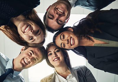 Buy stock photo Low angle shot of a group of young businesspeople huddled together in solidarity