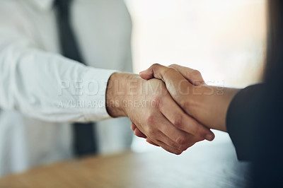 Buy stock photo Cropped shot of a businessman and businesswoman shaking hands in a modern office
