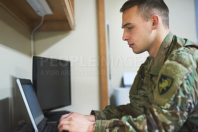 Buy stock photo Shot of a young soldier using a laptop in the dorms of a military academy