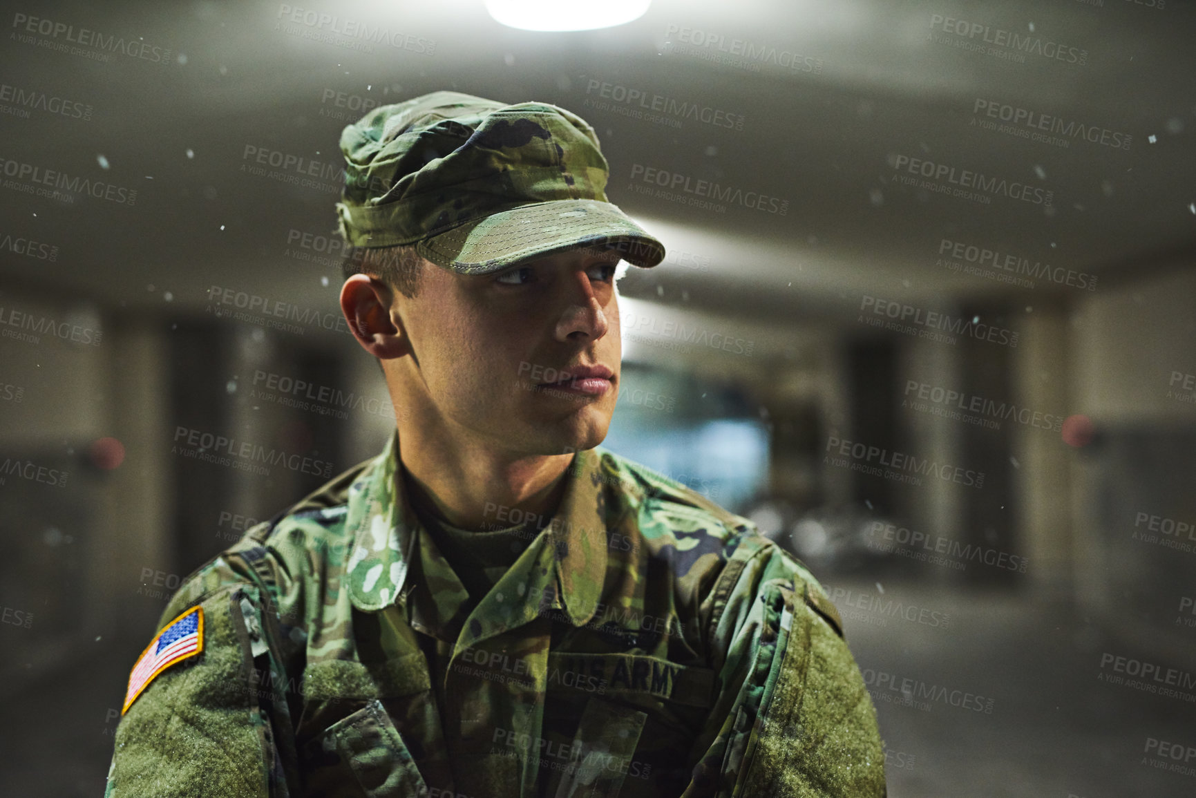 Buy stock photo Shot of a young soldier standing outside on a cold night at a military academy