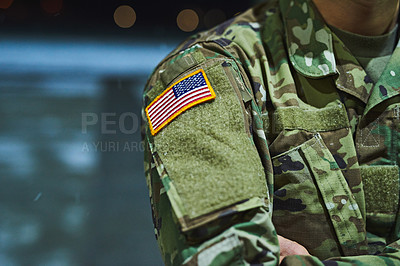 Buy stock photo Cropped shot of a soldier wearing camouflage fatigues with an american flag for a patch