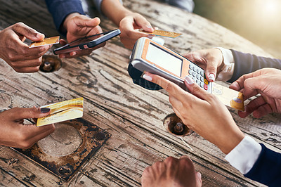 Buy stock photo High angle shot of a group of businesspeople paying their bills with credit cards while being seated around a table outside during the day