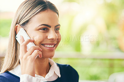 Buy stock photo Shot of a cheerful young woman talking on her cellphone while standing inside of a cafe during the day