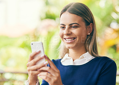Buy stock photo Shot of a focussed young woman browsing on her cellphone while standing inside of a cafe during the day