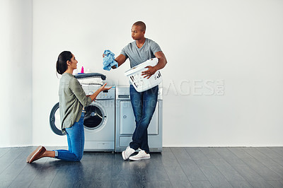 Buy stock photo Shot of a young woman doing laundry at home