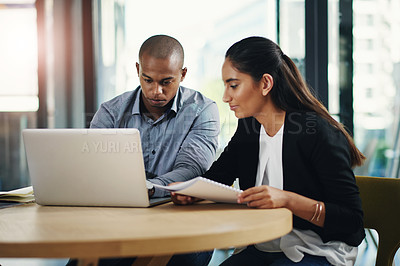 Buy stock photo Shot of two businesspeople working together on a laptop in an office