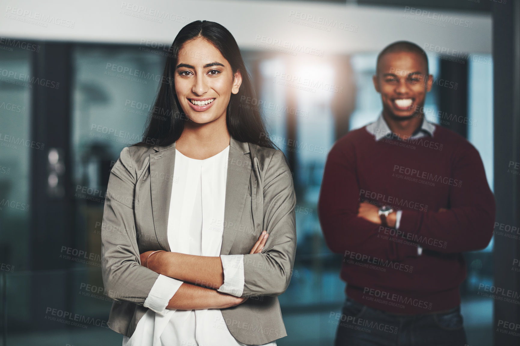 Buy stock photo Portrait of a young businesswoman standing in an office with her colleague in  the background