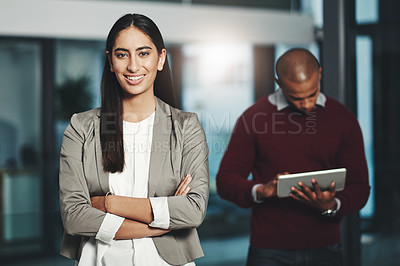 Buy stock photo Portrait of a young businesswoman standing in an office with her colleague in  the background