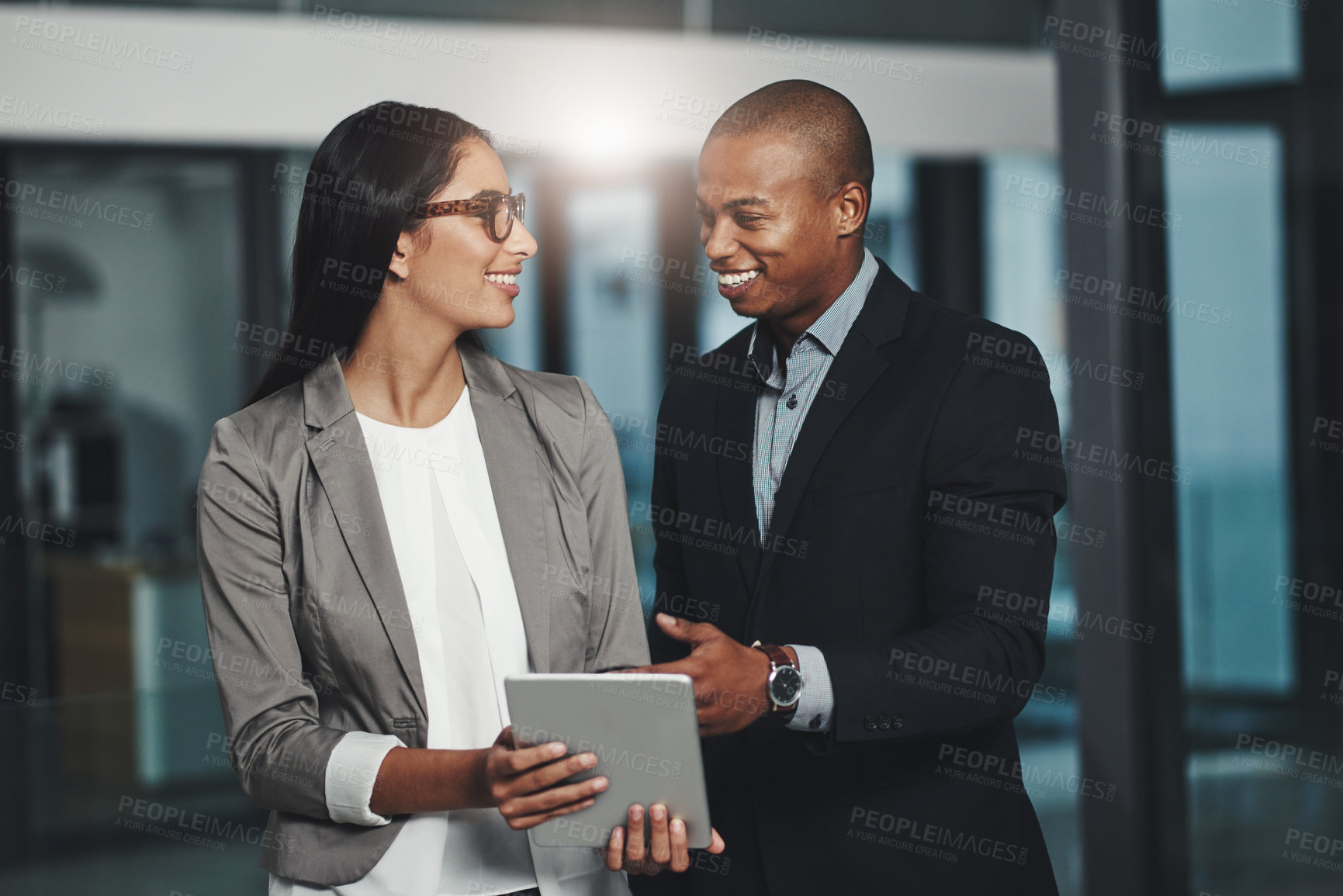 Buy stock photo Shot of two businesspeople working together on a digital tablet in an office